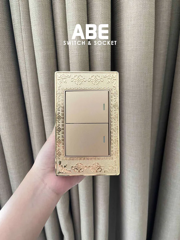 Mẫu công tắc Lace vàng chữ nhật, mặt viền được làm từ hợp kim kẽm phủ sơn tĩnh điện màu vàng ánh kim